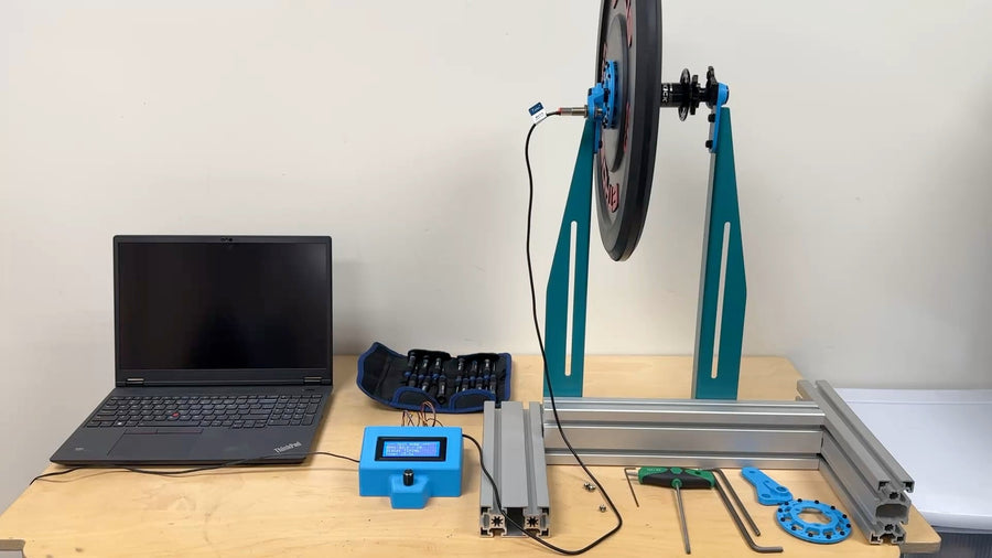 The spin-down test stand on the bench, the weighted plate and hub in the frame with the laptop and data logger alongside.