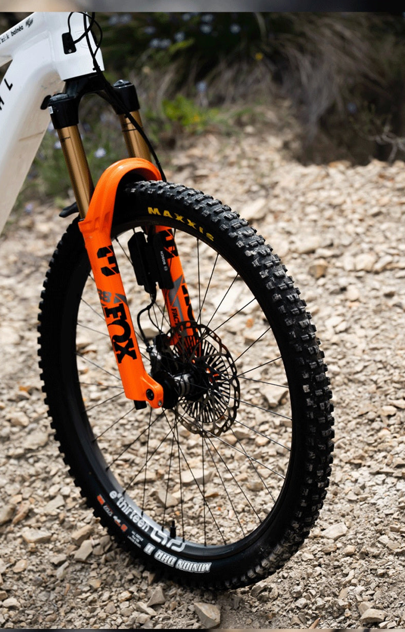 The front wheel of Alex Rudeau's Meta SX Power 800, an orange Fox 38 fork over a Grappler Flux carbon rim