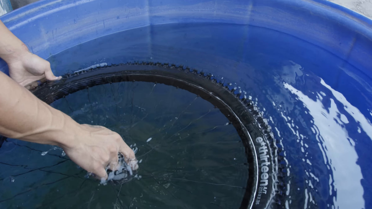 An e*thirteen tire held under water in the leak test tank. Still from Freehub Magazine's film Made With Love.