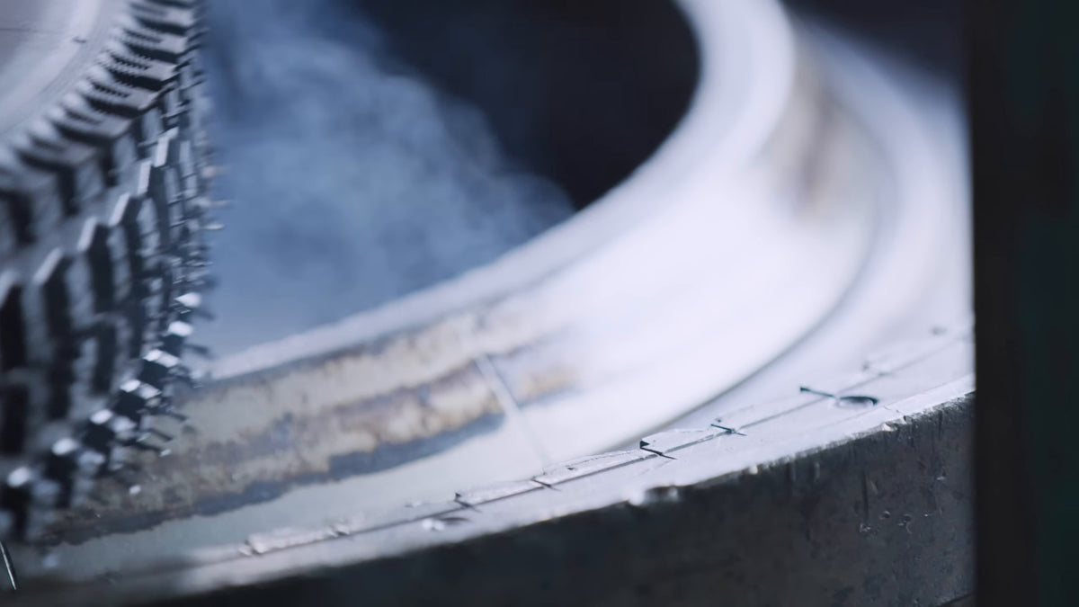 A cured e*thirteen tire coming out of its mold with steam still rising. Still from Freehub Magazine's film Made With Love.