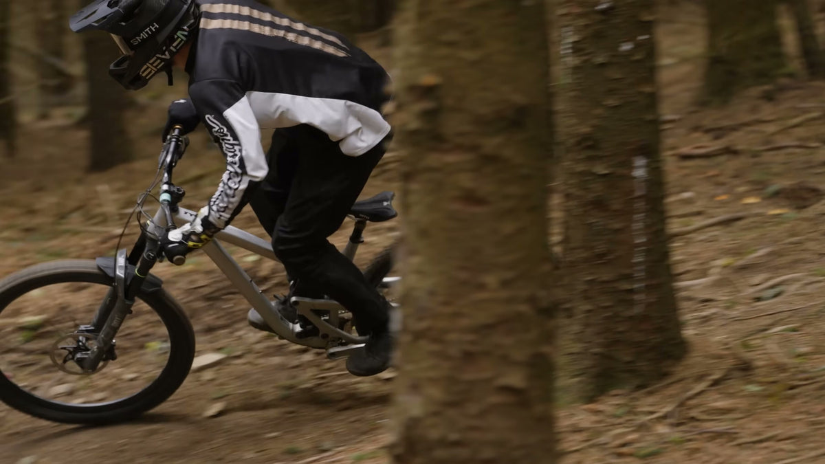 A rider railing a loamy corner through the pines at Redwood Park.